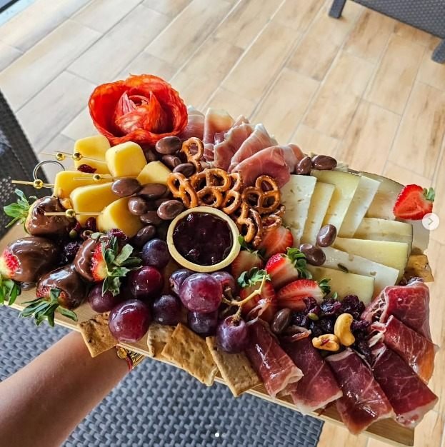 Mesa de charcutería cocomiel.pty con quesos, embutidos curados y frutas