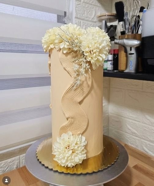 Torta artesanal con flores comestibles y textura ondulada, repostería cocomiel.pty